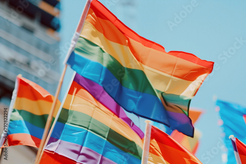 LGBTQ rainbow flags being waved in the air at a pride event.