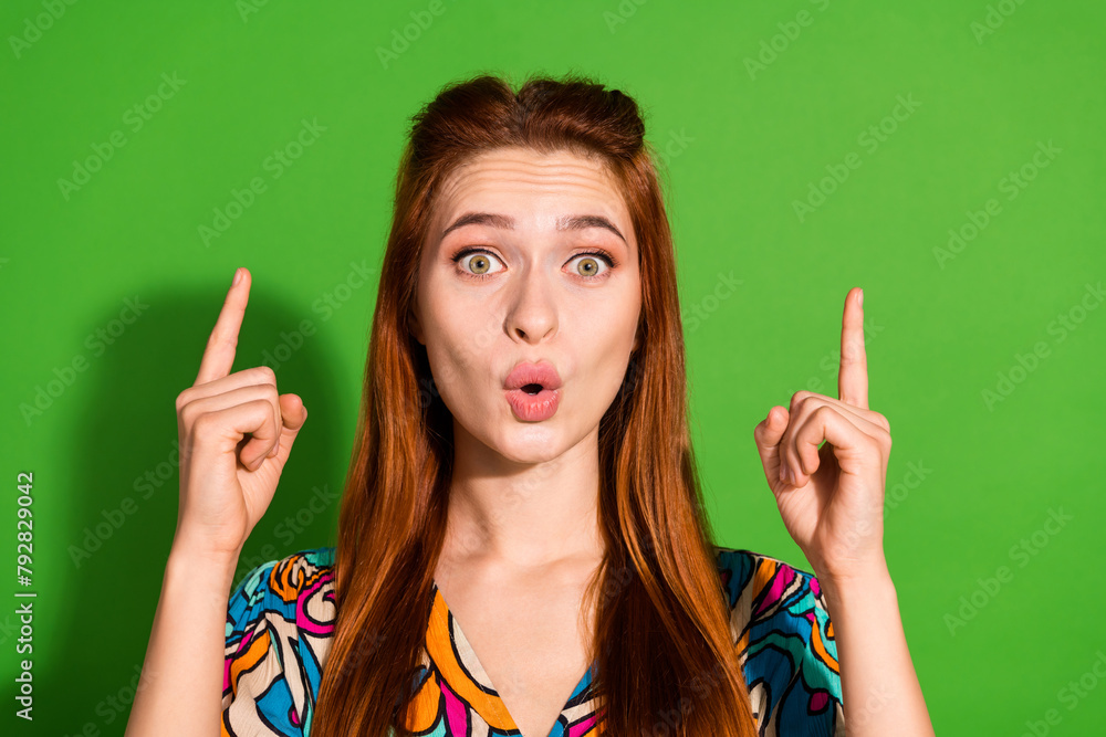 Photo portrait of attractive young woman point up shocked empty space dressed stylish retro clothes isolated on green color background Photo portrait of attractive young woman point up shocked empty space dressed stylish retro clothes isolated on green color background