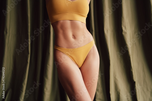 No retouch photo of stunning woman posing in yellow trendy top and panties isolated on fabric khaki color background