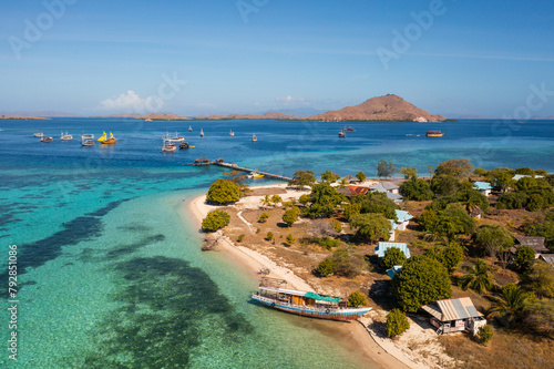 Komodo, Indonesia: An old wooden boat lies by the beach of the Kanawa island in Komodo near Labuan Bajo in Flores, Indonesia. photo