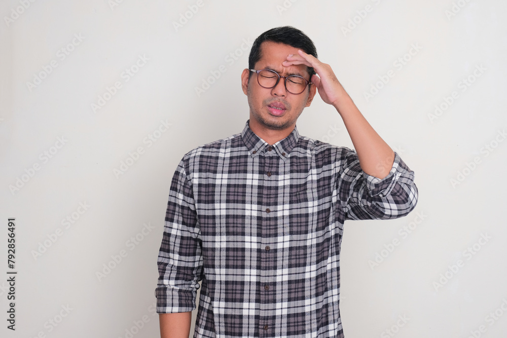A man touching his forehead suffering headache A man touching his forehead suffering headache