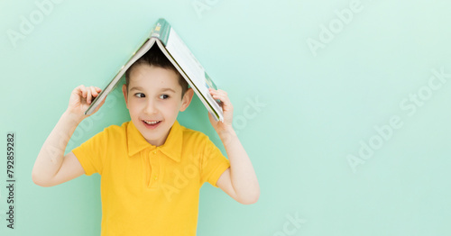 Boy holds book on a head