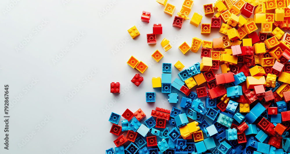 Fototapeta premium Colorful assorted building blocks scattered on white background