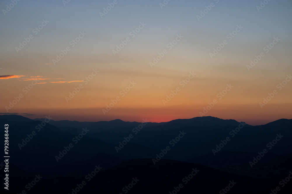 Silhouette of the hills at sunset with hazy sky.