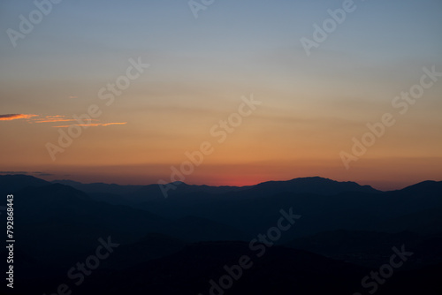 Silhouette of the hills at sunset with hazy sky.