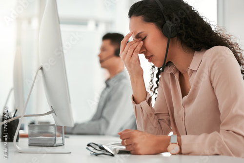 Stress, headache and woman customer service consultant with computer in office with burnout for crm. Migraine, exhausted and female with headset for technical support, telemarketing or call center. photo