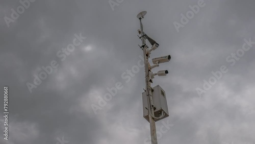 Time lapse. Wi-fi Trafic surveillance CCTV camera and cloudscape in background. Cloudy day and cloud moving fast. Electronic camera monitor the traffic and environment. Surveillance, security concept