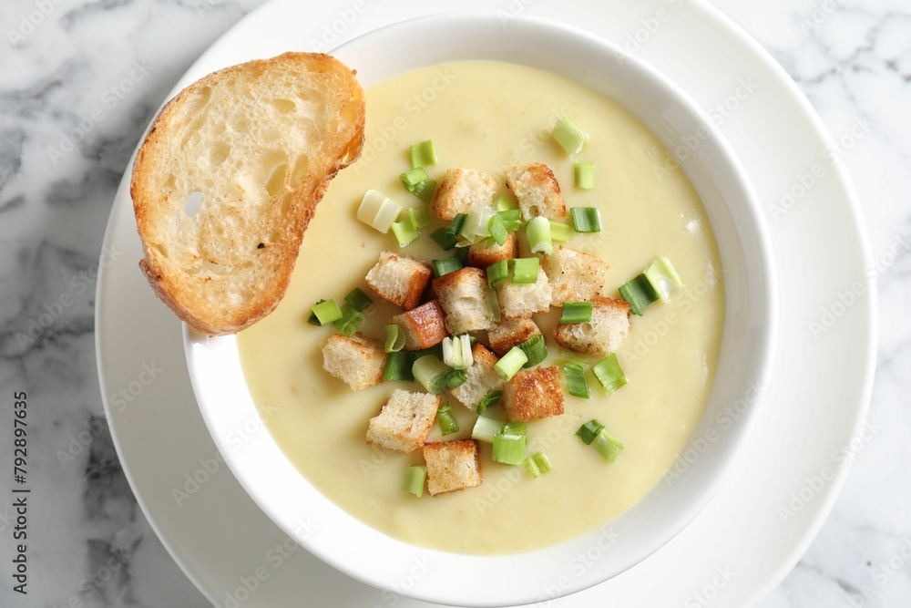 Tasty potato soup with croutons and green onion in bowl on white marble table, top view Tasty potato soup with croutons and green onion in bowl on white marble table, top view