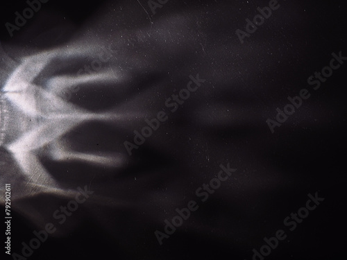 Light reflected on a steel surface in the dark for an abstract background, energy or mystery. 