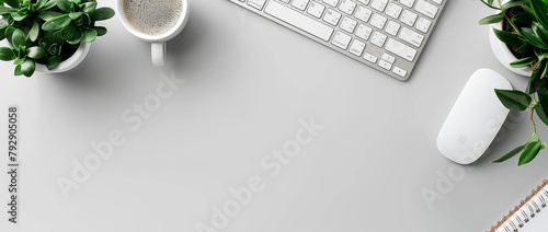 Photo of a modern office desk with a white keyboard, mouse and notebook on a grey background.