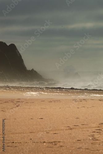 ondas a bater em rochas ao por do sol photo