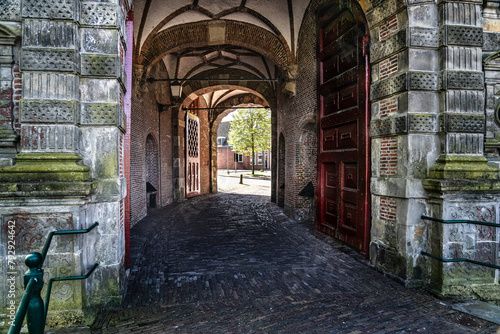 Curved cobblestone path leading through the mannerism architectural style Oosterpoort city gate, a 17th century gate in Hoorn North Holland, Netherlands. photo