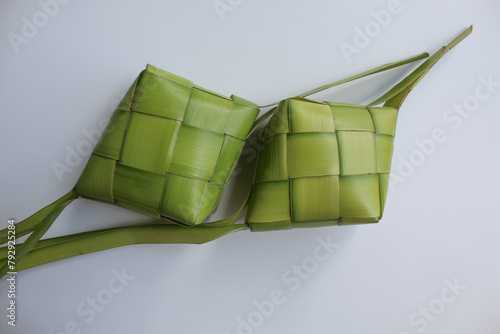 Ketupat wrap, woven young coconut leaves, before cooked. Isolated on white background photo