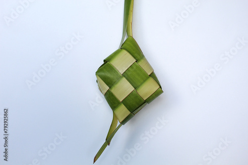 Ketupat wrap, woven young coconut leaves, before cooked. Isolated on white background photo