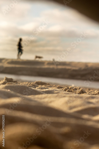 pessoas a passear com cão ao por do sol  photo