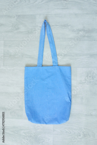 Blue shopper bag cotton fabric on a white wooden background.