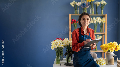 Portrait of young latin woman florist smiling confident standing at flower shop.