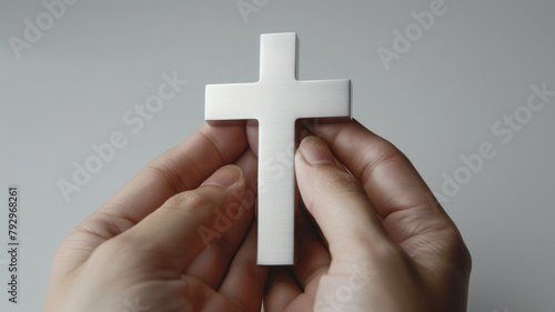 Hands holding a white cross