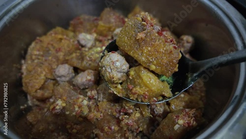 Someone is cooking Sambel Goreng Krecek that made from buffalo or cow skin using a pot. Concept for Indonesian Eid al fitr celebration. photo