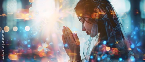 The image shows a girl praying and worshiping in the church, with her hands folded in prayer, representing faith, spirituality and religion, and with her hands raised in praise as the background. photo