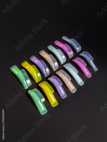 Multi-colored rollers for laminating eyelashes on black background. Silicone rollers for eyelash lamination photo