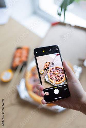 Photo of pizza on phone with hand