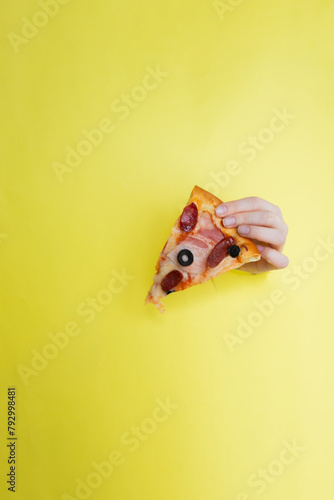 Petite pizza on yellow background with hand