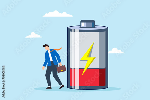 Tired businessman with low battery illustrating exhaustion, fatigue, and burnout resulting from hard work. Concept of stress, anxiety, and potential depression from unhealthy work habits