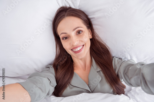 Top view photo of sweet pretty lady wear grey nightwear lying bed tacking selfie indoors apartment bedroom