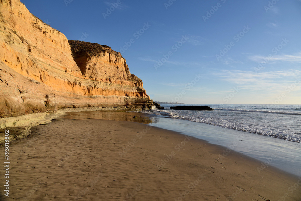 A sand rock mountain next to a beach, shot during golden hour. Taken near San Diego in United States, at the Atlantic Ocean. 