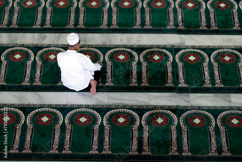 Al Akbar Surabaya National Mosque.  Muslim man praying and whorship on carpet with arches designed to point towards Mecca..