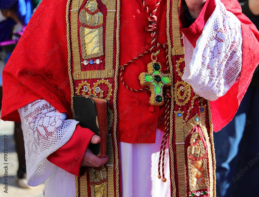 priest with religious dress during the blessing with the bible in his hand