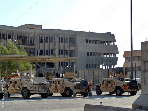 Military vehicles parked in front of a bombed out building at FOB Loyalty during Operation Iraqi Freedom in Baghdad, Iraq © Angela