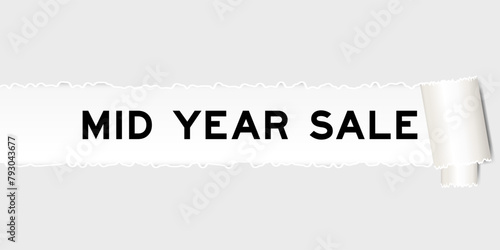 Ripped gray paper background that have word mid year sale under torn part