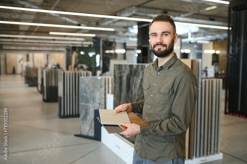 Man choosing tile among different samples in store