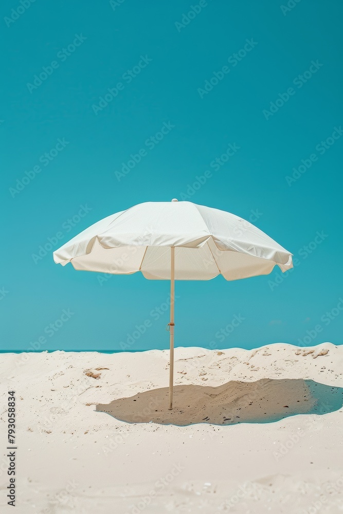A photo of a beach with a white beach umbrella.