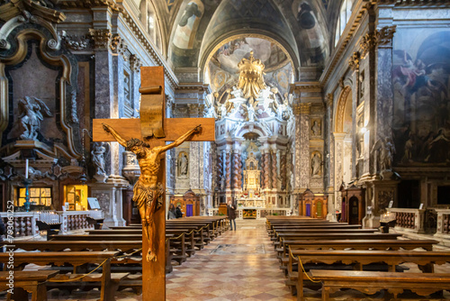 A crucifix inside Church of the Scalzi (Santa Maria di Nazareth) in Venice; Veneto, Italy; Beautiful ornaments and statues; Defocused people in the background