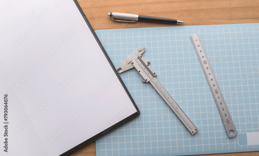 objects to start a project such as a pad of paper, caliper, pen and ruler on the table objects to start a project such as a pad of paper, caliper, pen and ruler on the table