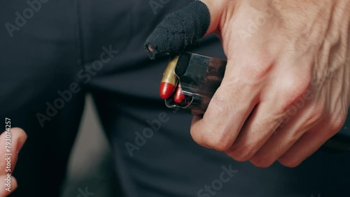Reloading a weapon close-up macro. Adding cartridges to the firearms magazine. Semi-automatic 9mm pistol and bullets photo