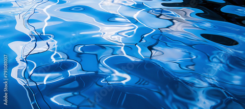 A mesmerizing dance of light and shadow on the reflective surface of a blue liquid.