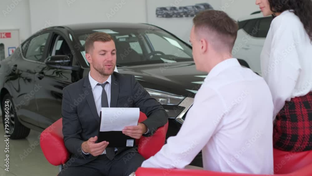 A young married couple buys a new car at a luxury car dealership. A young married couple buys a new car at a luxury car dealership.