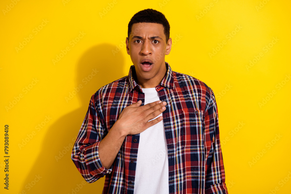 Photo of shocked confused worried nervous man hand chest open mouth unexpected unbelievable news isolated on yellow color background Photo of shocked confused worried nervous man hand chest open mouth unexpected unbelievable news isolated on yellow color background