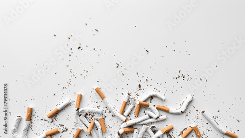 Discarded crushed broken cigarettes and scattered tobacco on white background, representing cessation and the end of smoking with copy space. No tobacco day.