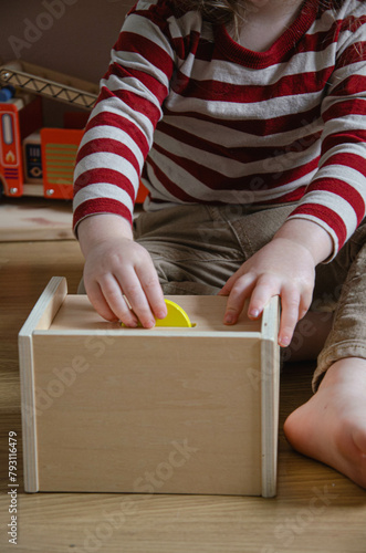 Enfant qui joue avec une boite permanence de l'objet Montessori photo