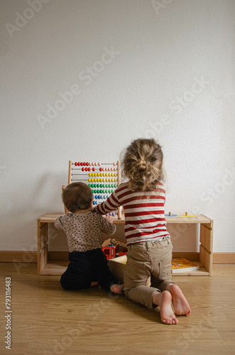 Un enfant et un bébé qui jouent dans une chambre d'enfant Montessori
