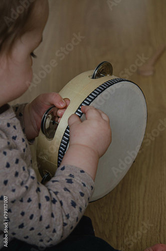 Bébé qui joue du tambour dans une chambre Montessori photo