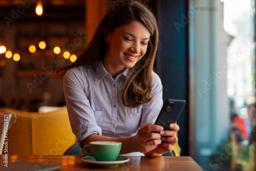 Business woman using phone in coffee shop