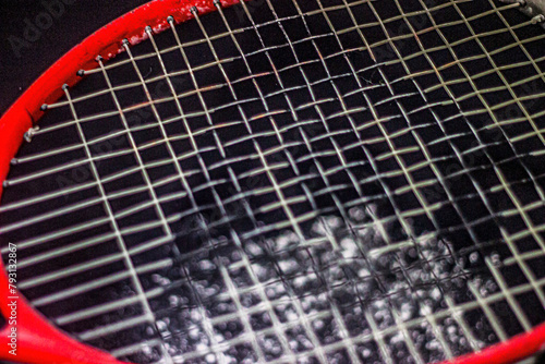 Scattered white powder on a black background and a tennis racket in the foreground