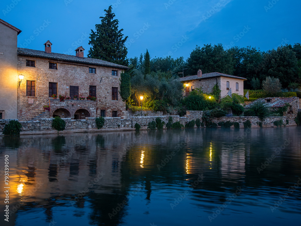 Naklejka premium Sunrise at Bagno Vignoni, a village nestled in the Val d'Orcia a few kilometres from Siena, where there is a large medieval stone pool where the water gushes out smoking from the thermal spring