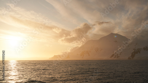 Sunset behind Antarctic Mountains on a Semi Cloudy Day photo